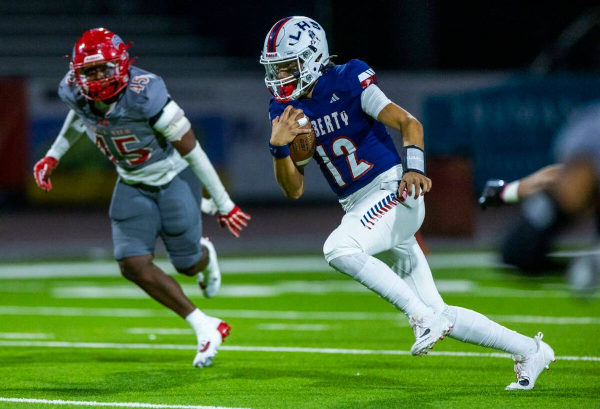 Liberty quarterback Elijah Espinoza (12) takes off on another run as Arbor View defensive linem ...