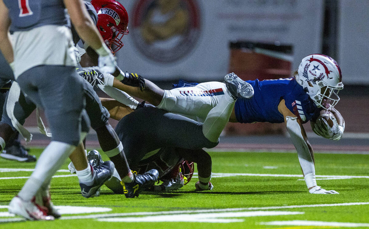 Liberty running back Ezra Sanelivi (1) extends for a few more yards as Arbor View safety Damien ...