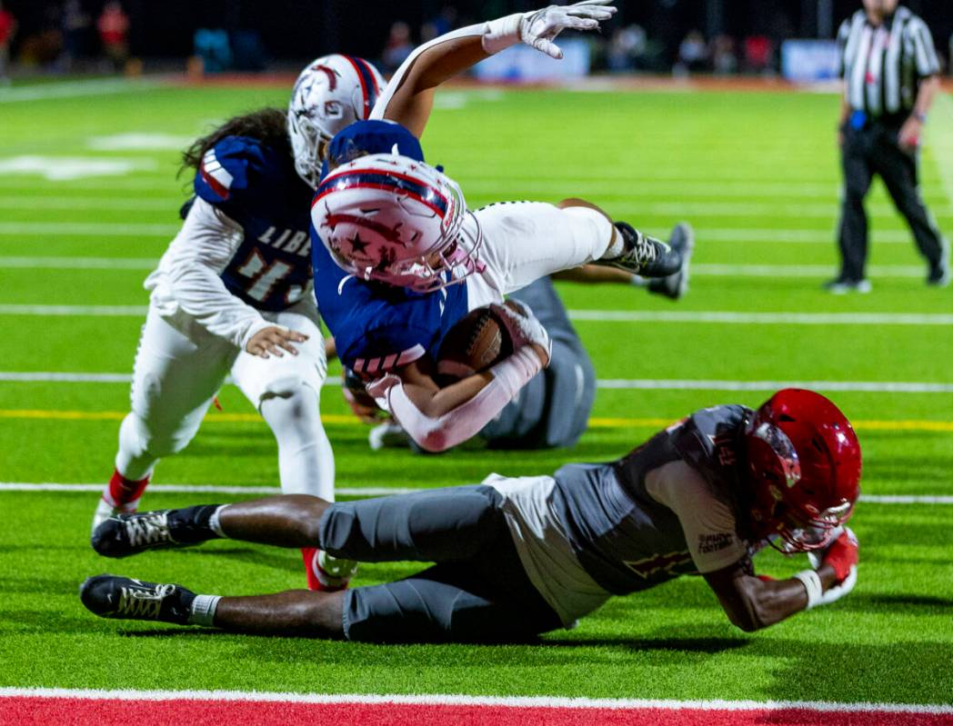 Liberty running back Ezra Sanelivi (1) flies in for a touchdown as Arbor View cornerback JT Col ...