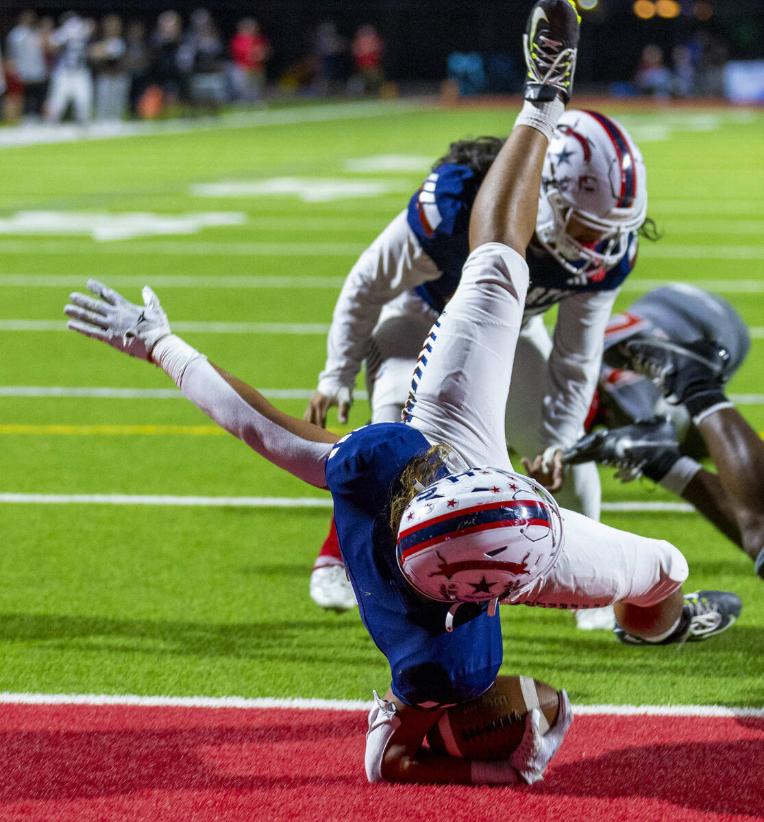 Liberty running back Ezra Sanelivi (1) flies in for a touchdown as Arbor View cornerback JT Col ...