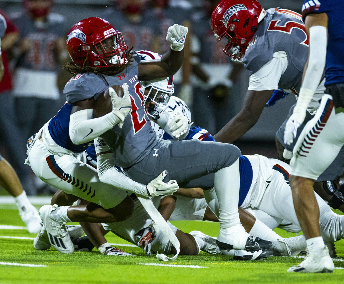 Arbor View running back Kamareion Bell (20) fights for a few more yards against Liberty defende ...