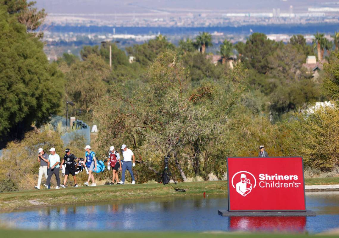 Players and their caddies walk toward green No.18 during the third round of the Shriners Childr ...