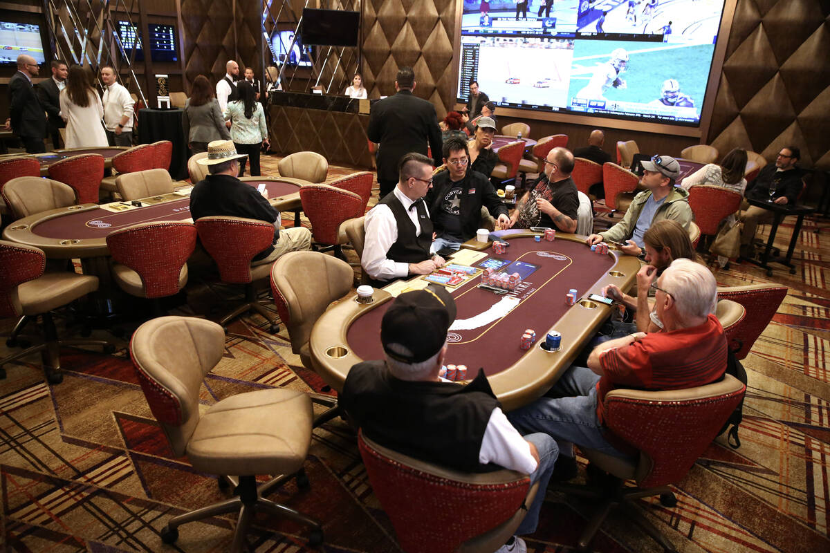 Players participate in the first poker game during the grand opening event for the new poker ro ...