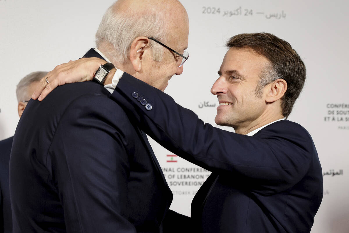 France's President Emmanuel Macron hugs Lebanon's Prime Minister caretaker Prime Minister Najib ...