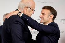 France's President Emmanuel Macron hugs Lebanon's Prime Minister caretaker Prime Minister Najib ...