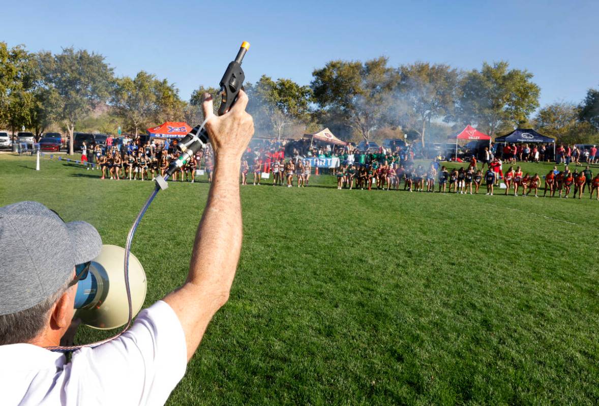 Michael O'Dea fires the starter pistol for the runners of the 4A Mountain girls cross country m ...