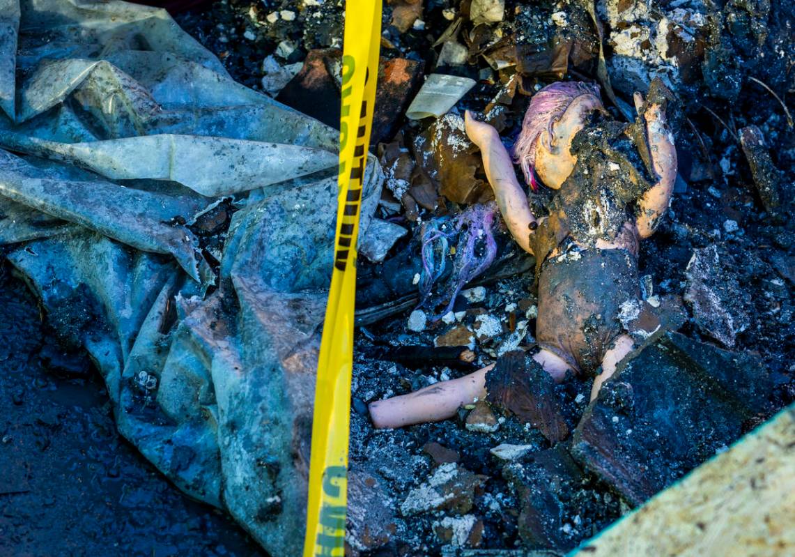 A baby doll lies in the debris about the exterior of fatal house fire at 8332 Langhorne Creek S ...