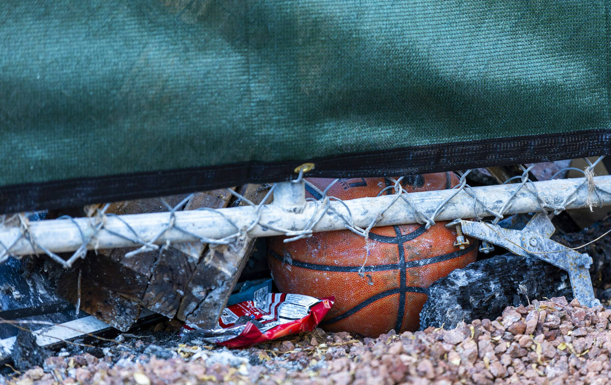 A basketball is wedged about emergency fencing around the exterior of fatal house fire at 8332 ...