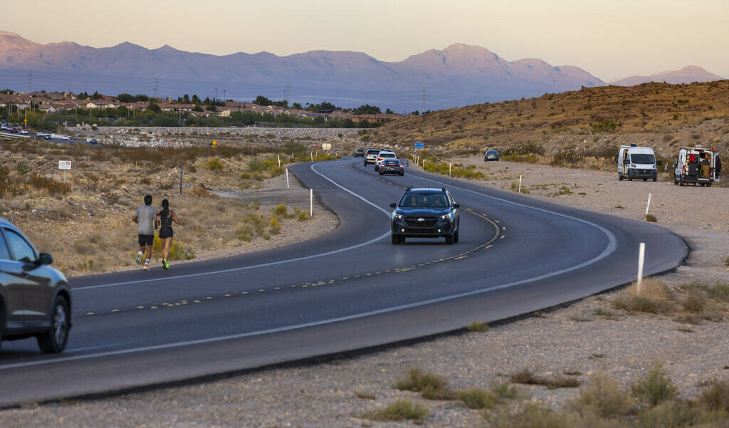 Runners move along SR 159 leaving the Red Rock National Conservation Area which is part of the ...