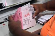 A worker handles mail-in ballots. (AP Photo/John Locher, File)