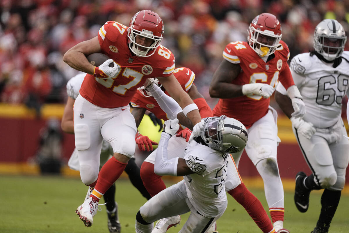 Kansas City Chiefs tight end Travis Kelce (87) pushes aside Las Vegas Raiders cornerback Nate H ...