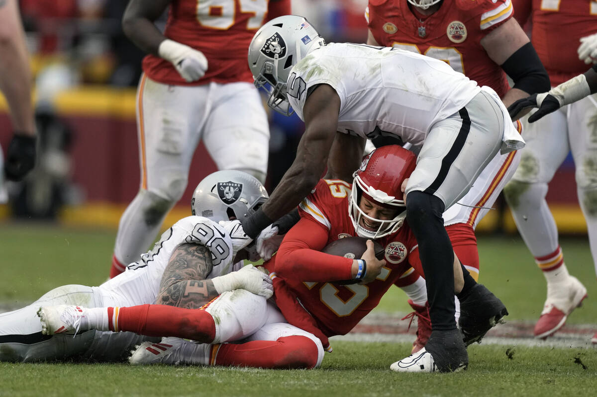 Kansas City Chiefs quarterback Patrick Mahomes (15) is stopped by Las Vegas Raiders defensive e ...