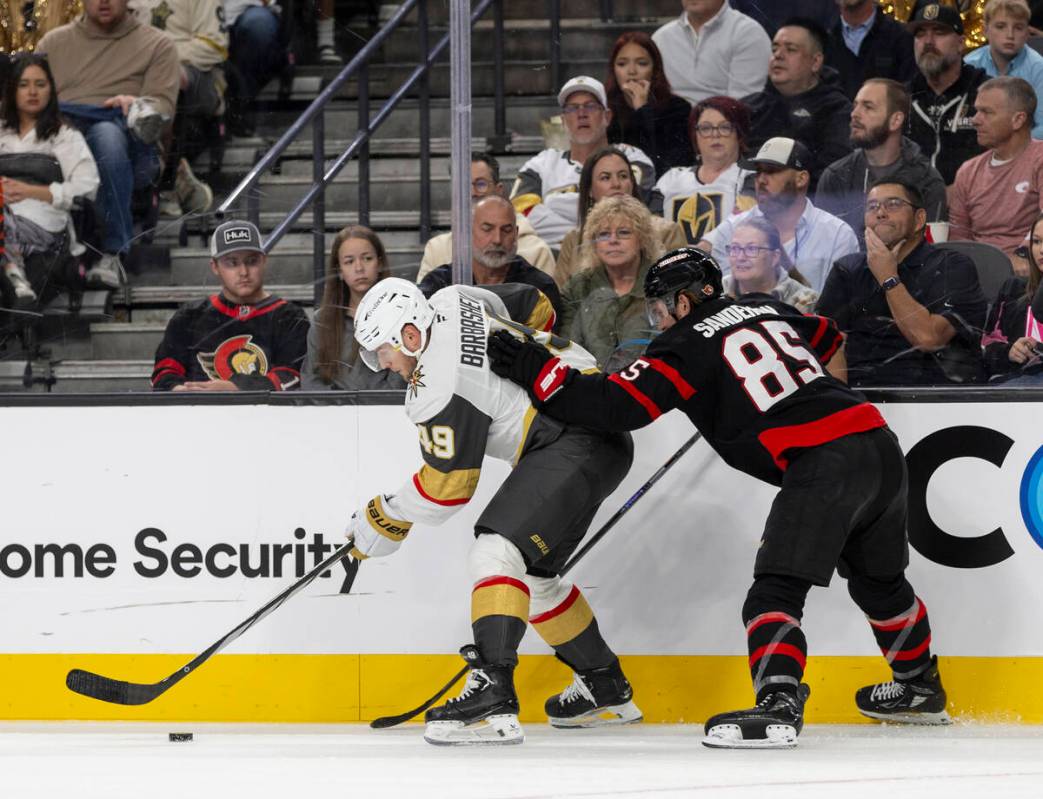 Golden Knights center Ivan Barbashev (49) and Ottawa Senators defenseman Jake Sanderson (85) fi ...