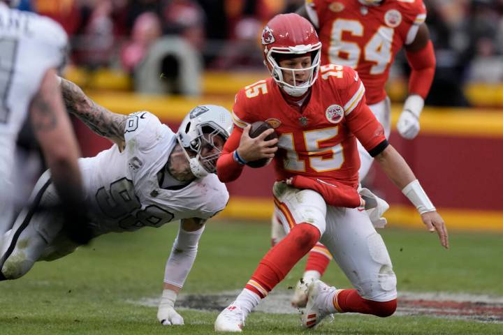 Kansas City Chiefs quarterback Patrick Mahomes (15) struggles for yardage as Las Vegas Raiders ...