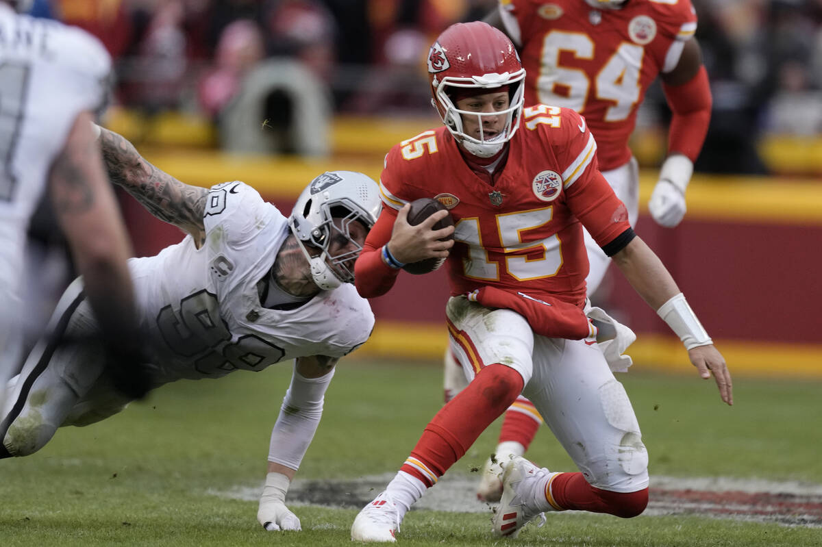 Kansas City Chiefs quarterback Patrick Mahomes (15) struggles for yardage as Las Vegas Raiders ...