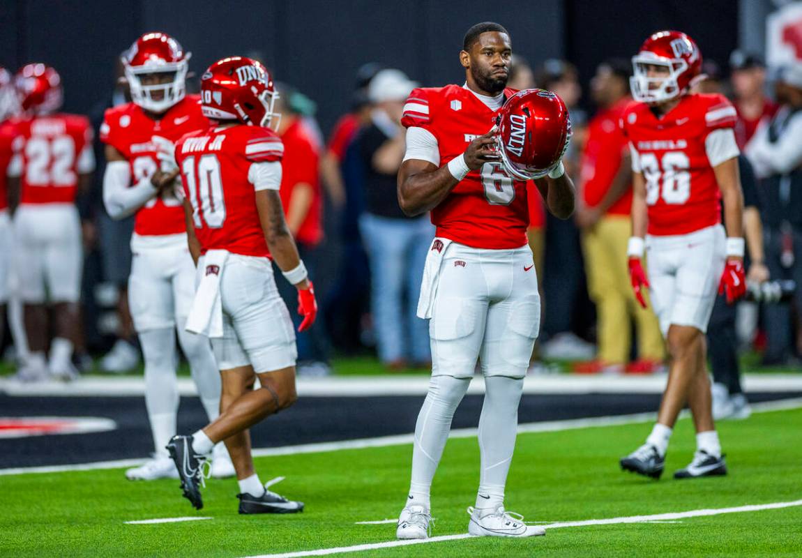 UNLV quarterback Hajj-Malik Williams (6) looks to Boise State players during warm ups of their ...