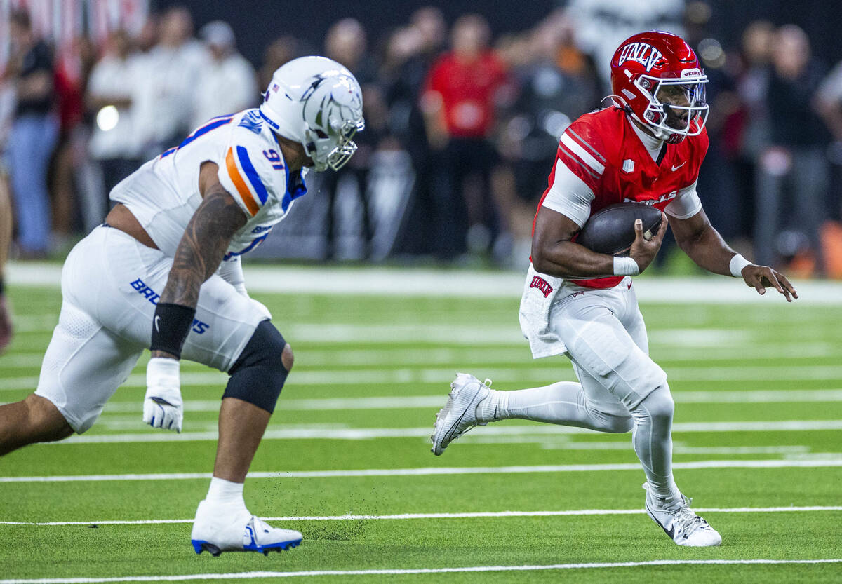 UNLV quarterback Hajj-Malik Williams (6) turns the corner on a run pursued by Boise State Bronc ...