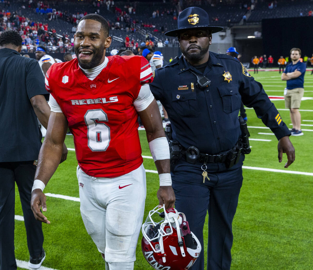 UNLV quarterback Hajj-Malik Williams (6) is escorted off the field after a gritty performance a ...