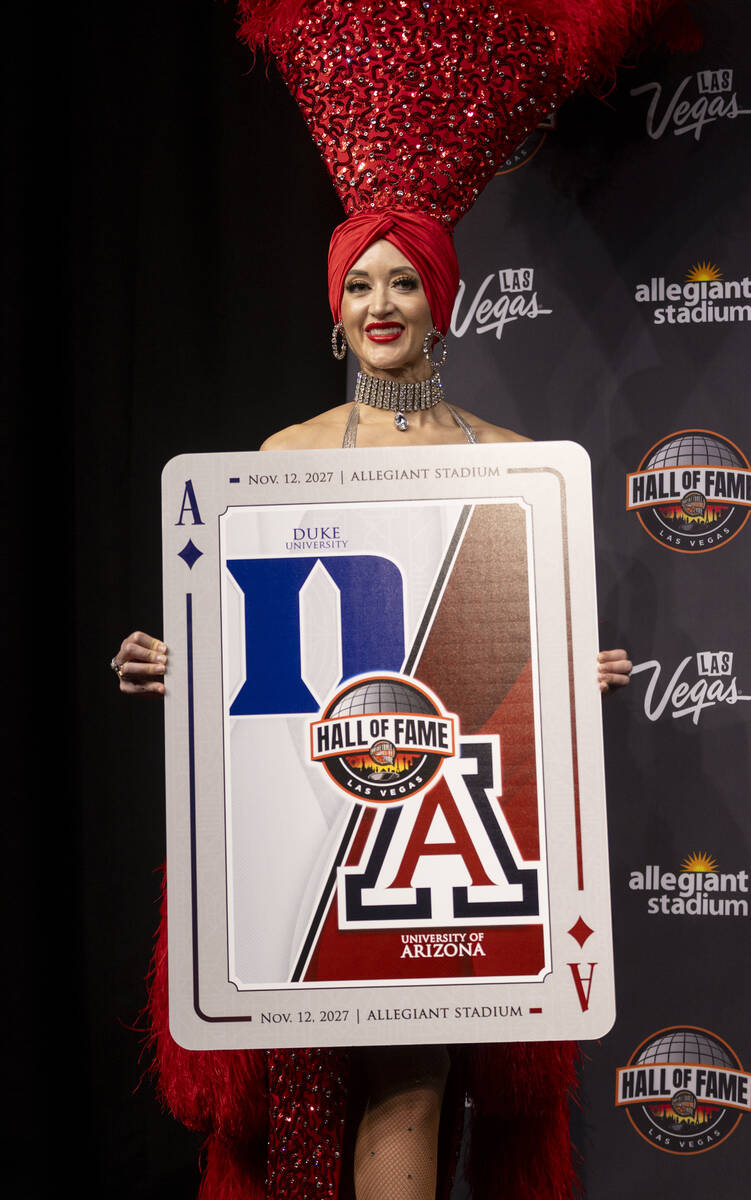 A showgirl holds a playing card revealing one of the scheduled games during the announcement of ...