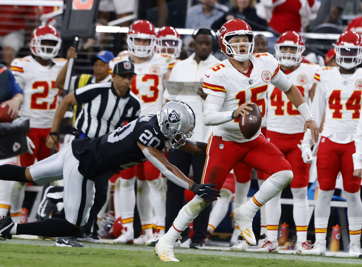 Kansas City Chiefs quarterback Patrick Mahomes (15) avoids a tackle from Raiders safety Isaiah ...