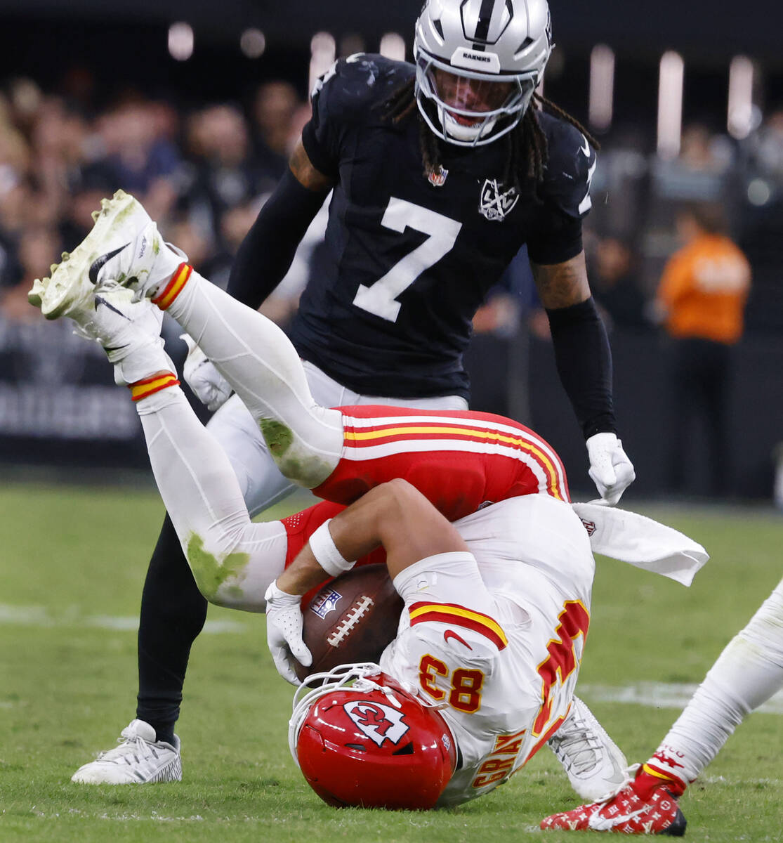 Kansas City Chiefs tight end Noah Gray (83) rolls over after catching a pass as Raiders safety ...