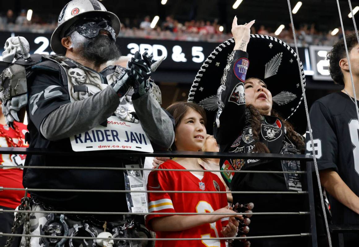 Kansas City Chiefs fan Sarah Greenblatt, 10, stands between Raiders fans as she watches an NFL ...