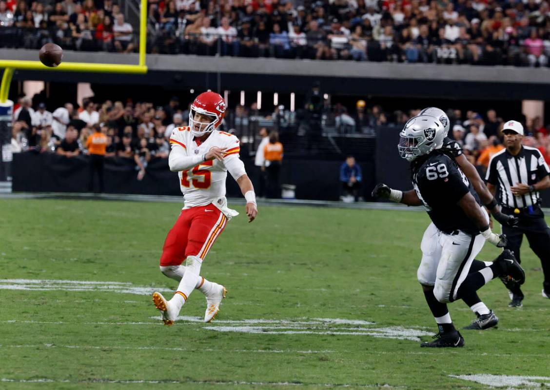 Kansas City Chiefs quarterback Patrick Mahomes (15) releases the ball as he is chased by Raider ...