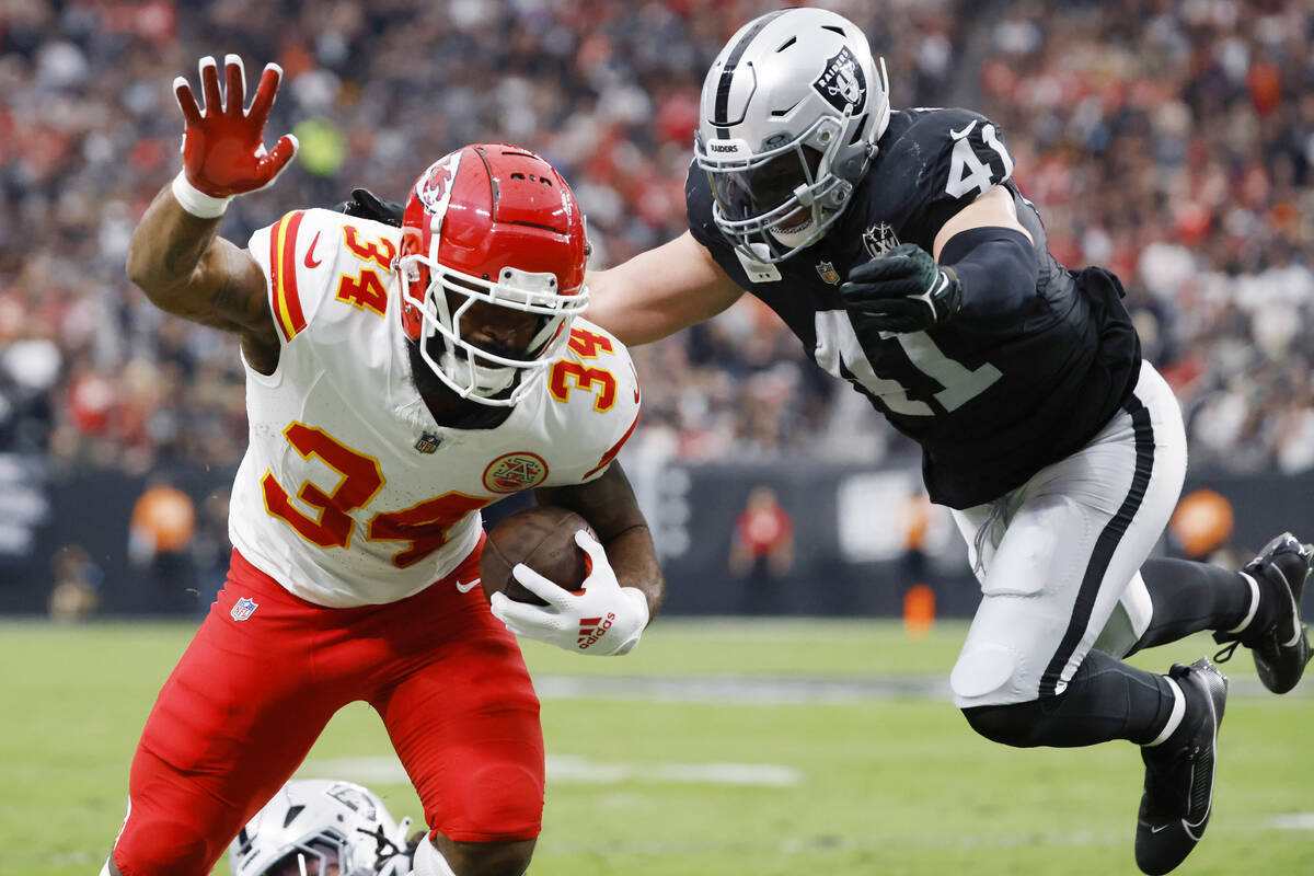 Kansas City Chiefs running back Samaje Perine (34) stretches for extra yards as Raiders linebac ...