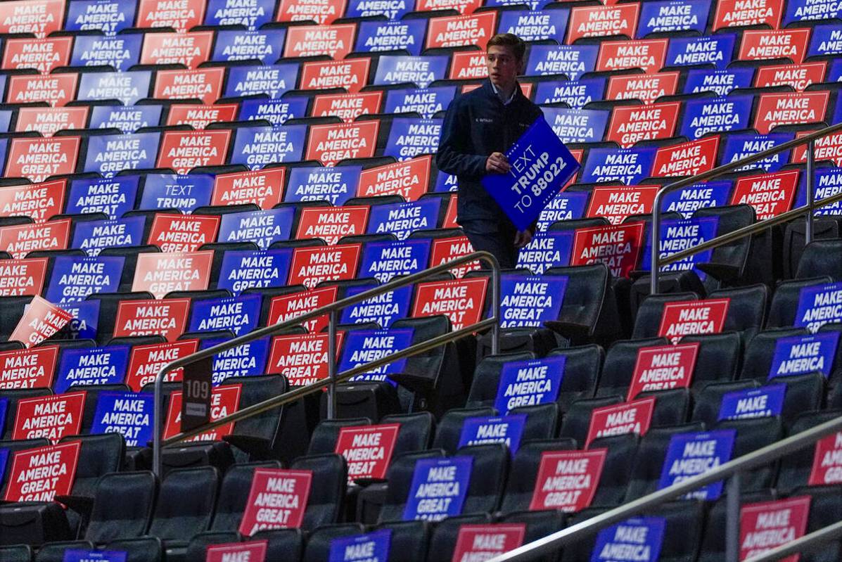 A worker places signs in seats before Republican presidential nominee former President Donald T ...