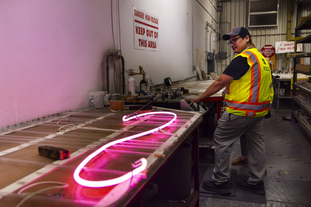 YESCO neon bender Oscar Gonzalez lights up a neon tube while working on the renovation of the & ...