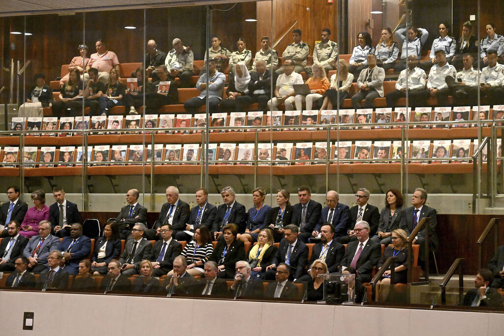 Posters with photos of Israeli hostages set in empty chairs are seen at the opening of the 25th ...