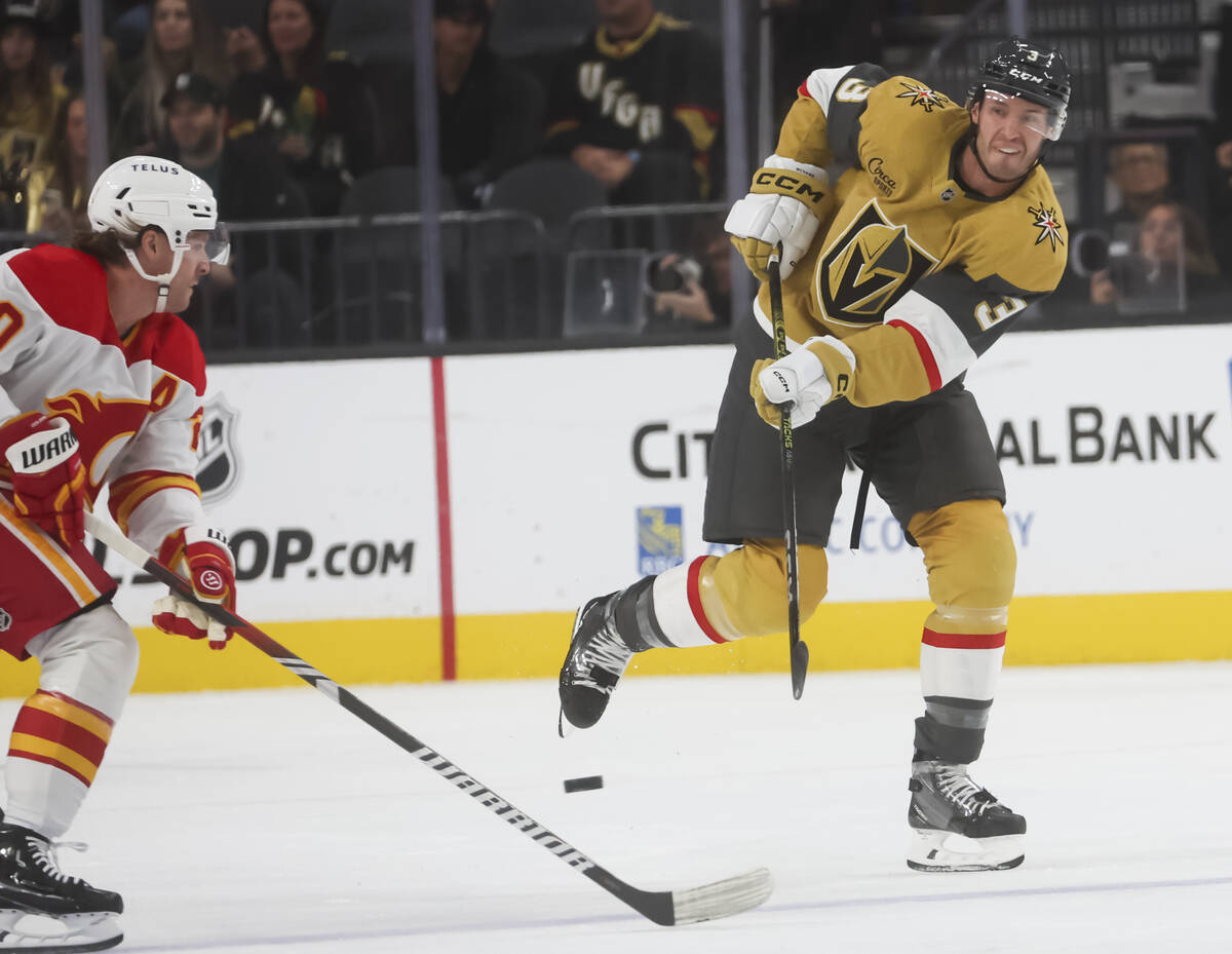 Golden Knights defenseman Brayden McNabb (3) sends the puck past Calgary Flames center Blake Co ...