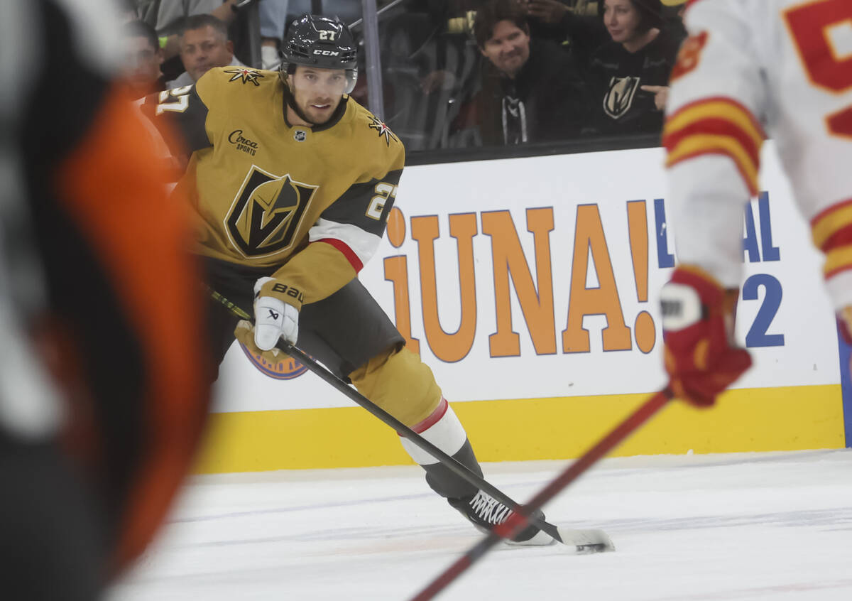 Golden Knights defenseman Shea Theodore (27) skates with the puck against the Calgary Flames du ...