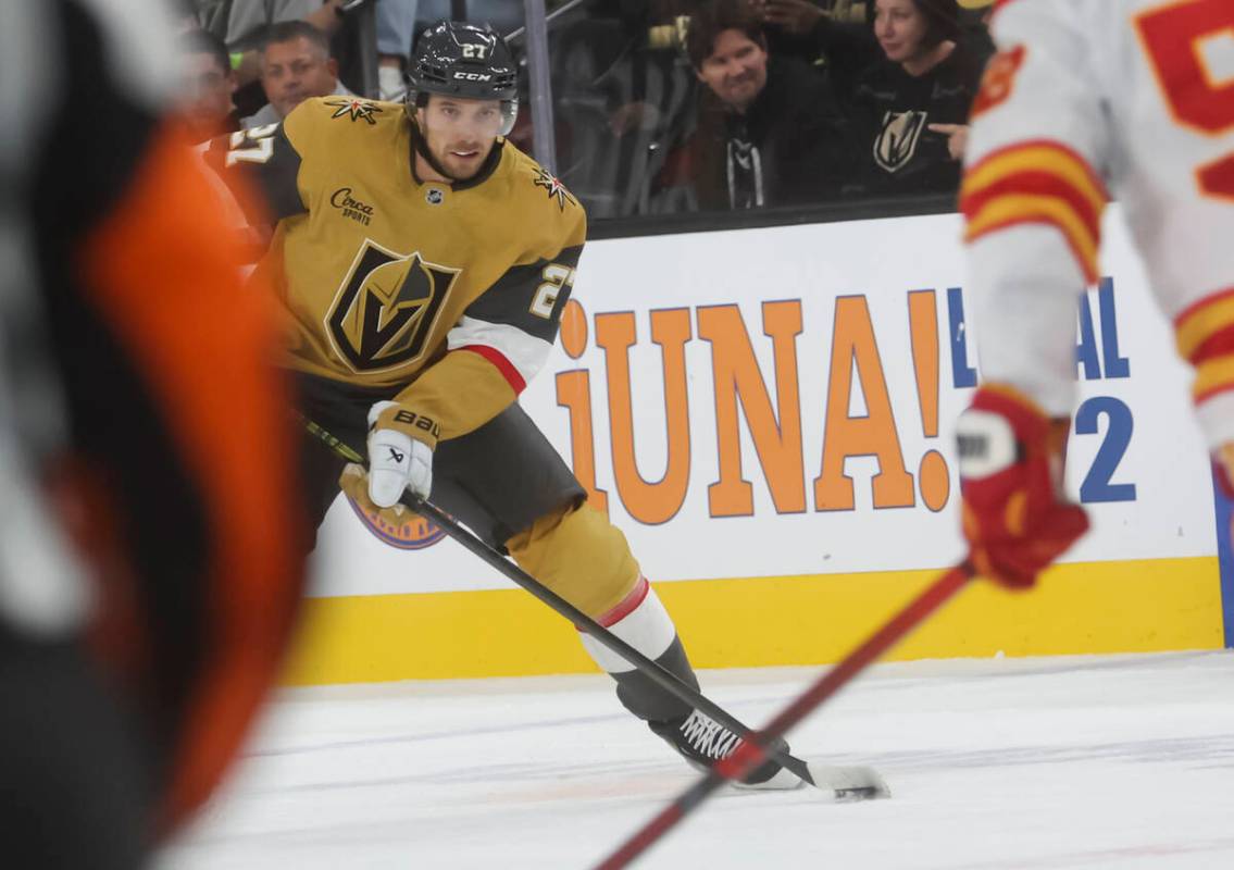 Golden Knights defenseman Shea Theodore (27) skates with the puck against the Calgary Flames du ...