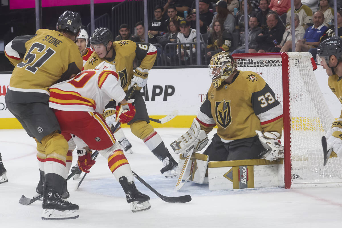 Golden Knights goaltender Adin Hill (33) defends the net against the Calgary Flames during the ...