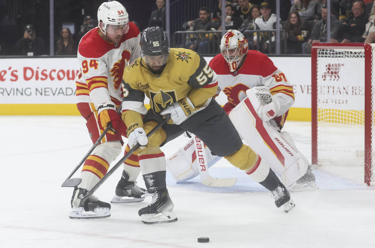 Golden Knights right wing Keegan Kolesar (55) moves the puck under pressure from Calgary Flames ...