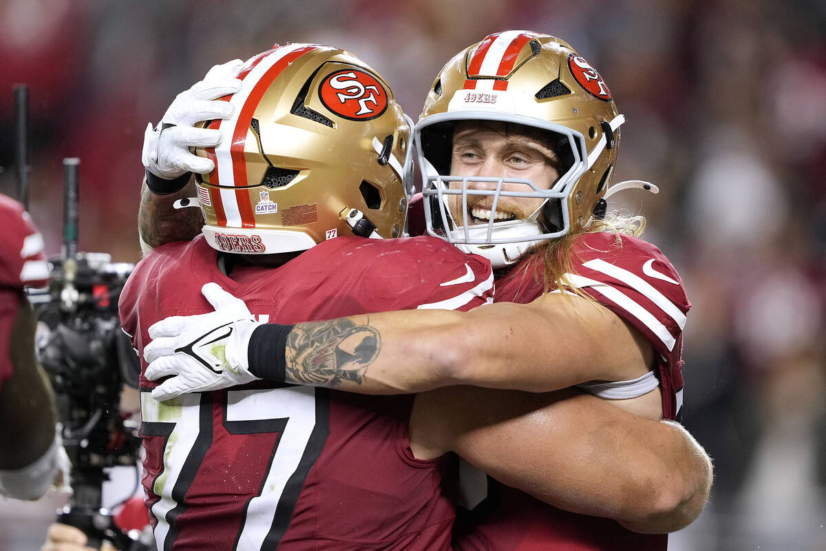 San Francisco 49ers tight end George Kittle, right, celebrates with guard Dominick Puni (77) af ...