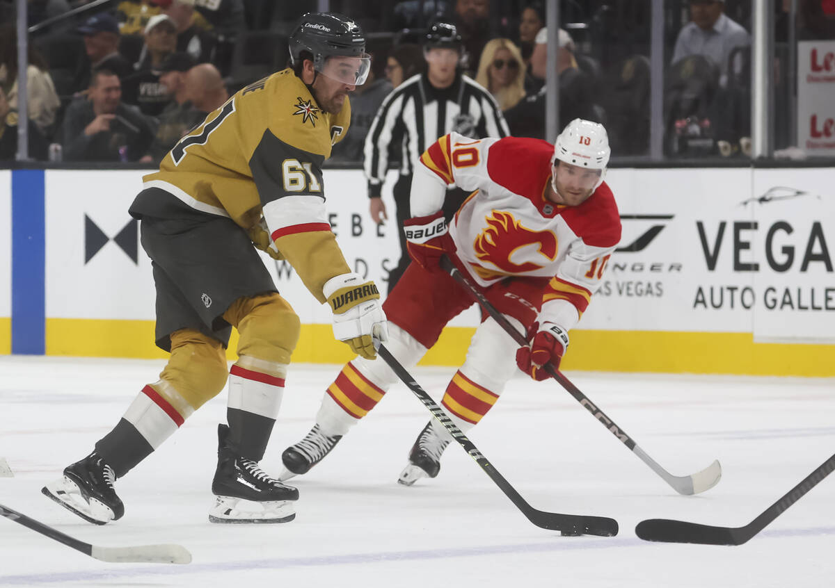 Golden Knights right wing Mark Stone (61) skates with the puck under pressure from Calgary Flam ...