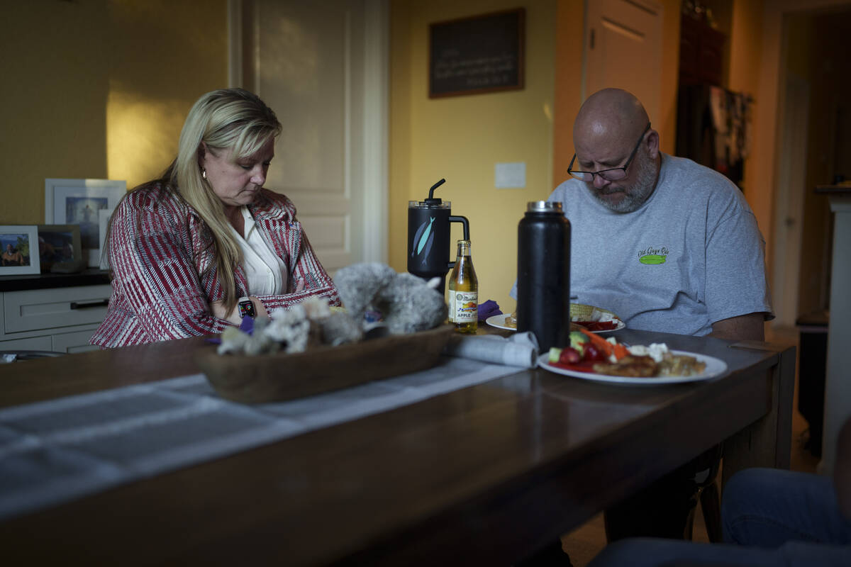 Cari-Ann Burgess, interim Registrar of Voters for Washoe County, Nev., left, prays with her hus ...