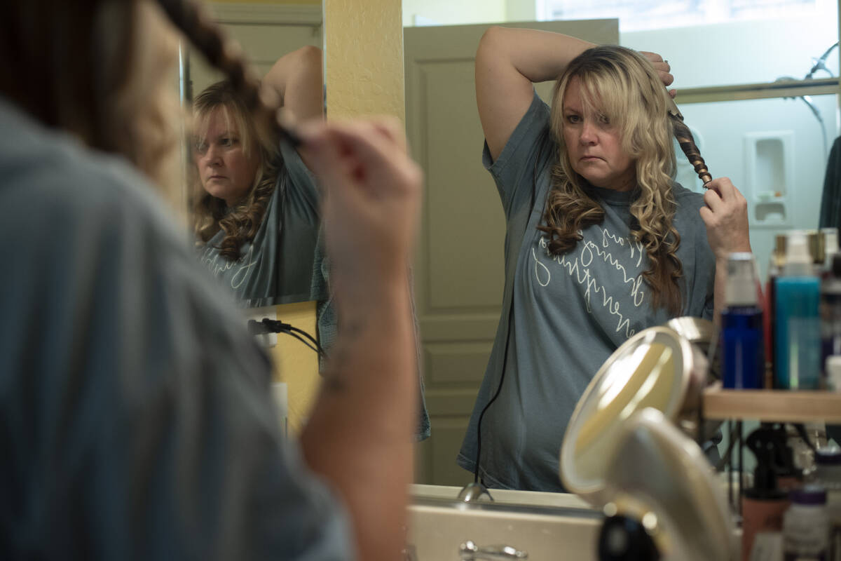 Cari-Ann Burgess, interim Registrar of Voters for Washoe County, Nev., curls her hair before ch ...