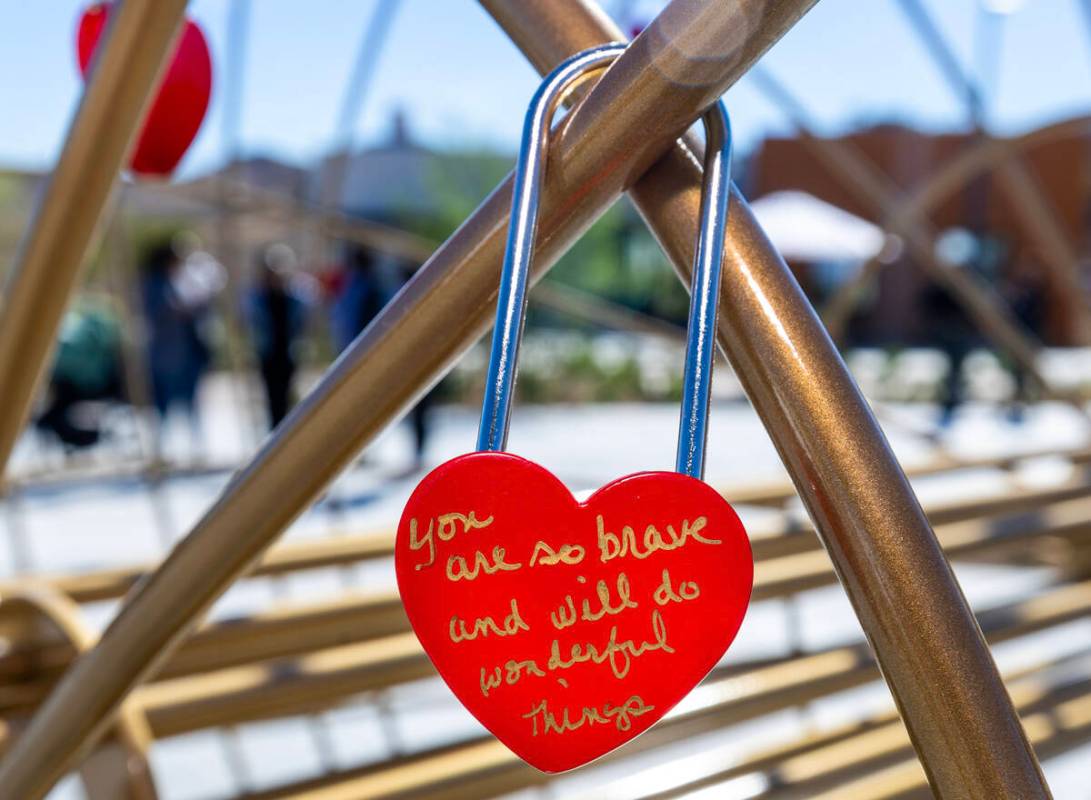 A Lock of Love is signed with a message and hung on a heart sculpture during St. Jude’s Ranch ...