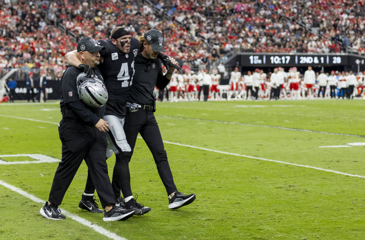 Raiders linebacker Robert Spillane (41) is helped back to the sideline during the first half of ...