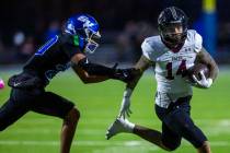 Green Valley cornerback Jerome Kosloske (20) attempts top stop Faith Lutheran running back Cale ...