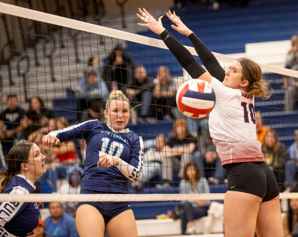 Centennial senior Abby Vlaming (10) spikes a ball past Coronado senior Rachel Schwartz (10) dur ...