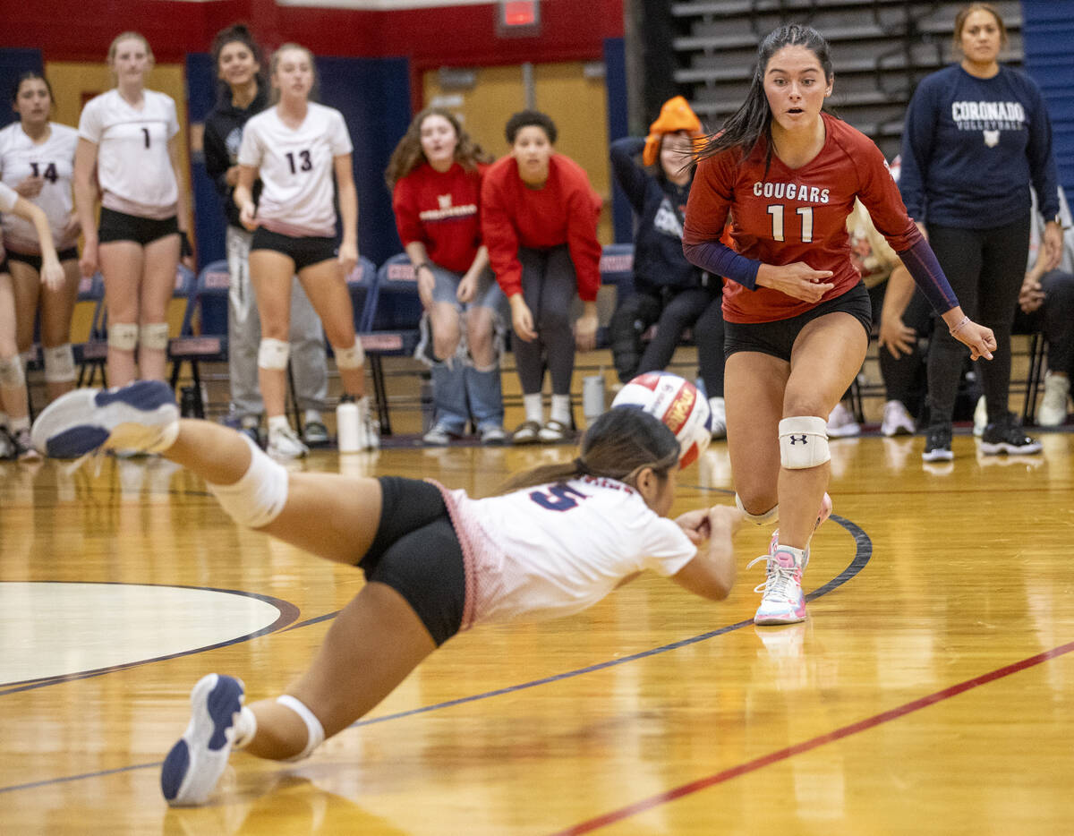 Coronado senior Reagan Vint (11) and the bench watch sophomore Isabelle Guerzon (5) dive for th ...