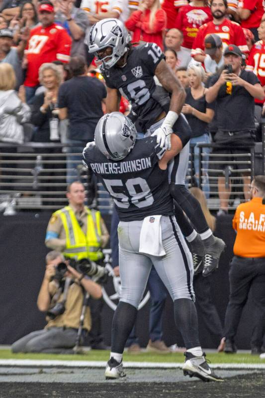 Raiders guard Jackson Powers-Johnson (58) hoists up wide receiver Jakobi Meyers (16) after his ...