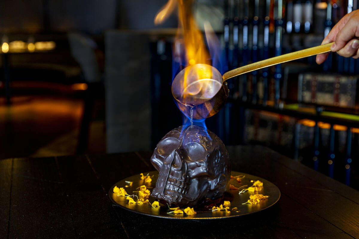 Hot chocolate mocha sauce is poured atop a Diablo Skull en Fuego dessert to reveal flan inside ...