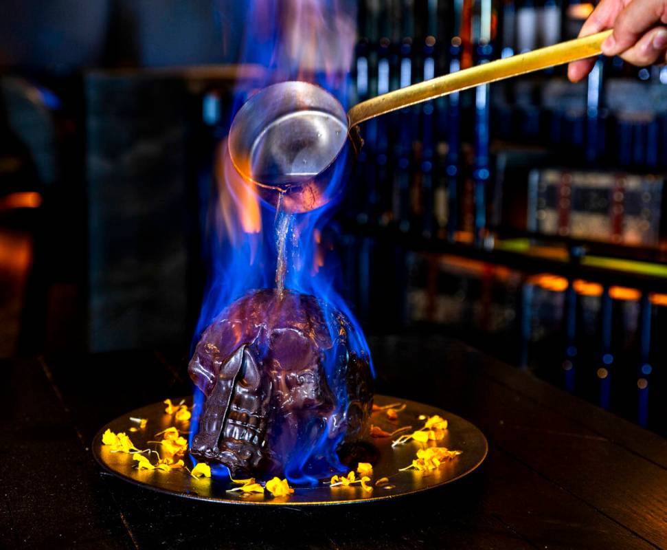 Hot chocolate mocha sauce is poured atop a Diablo Skull en Fuego dessert to reveal flan inside ...