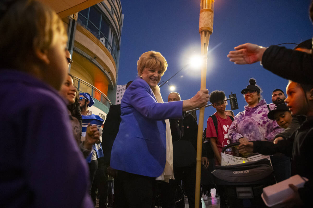 Las Vegas Mayor Carolyn Goodman walks with a torch for attendees to touch before the lighting o ...