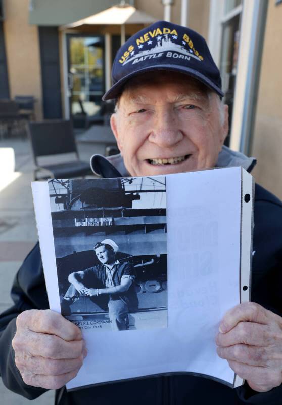 Dick Ramsey, 101, shows a photo of himself on the USS Nevada during an interview at a restauran ...